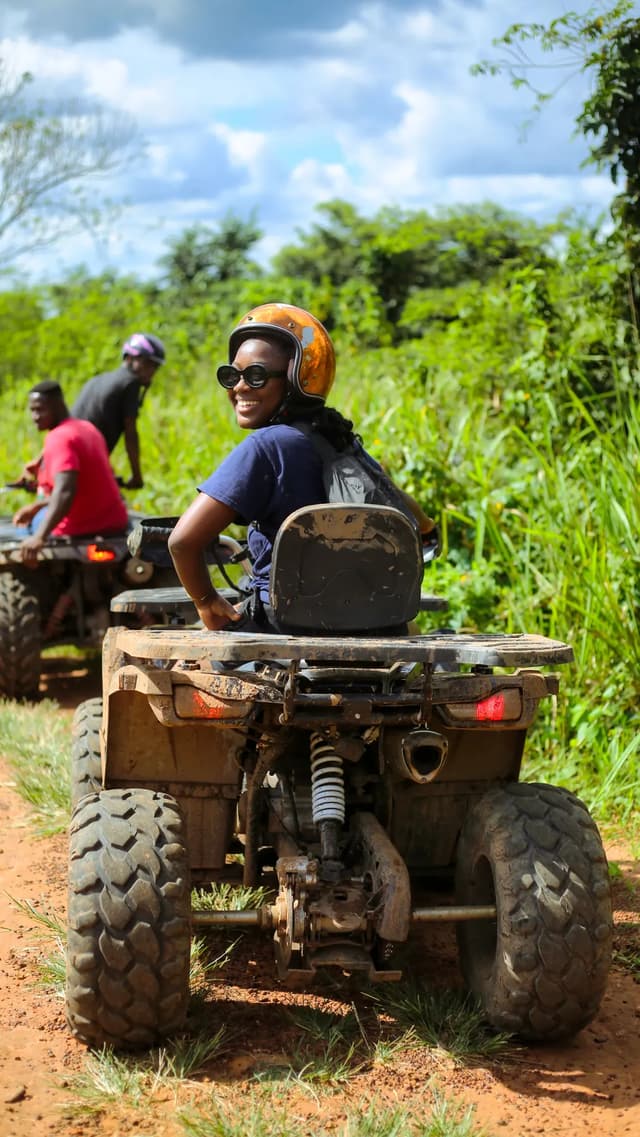 Quad rider travelling along a green dirt trail