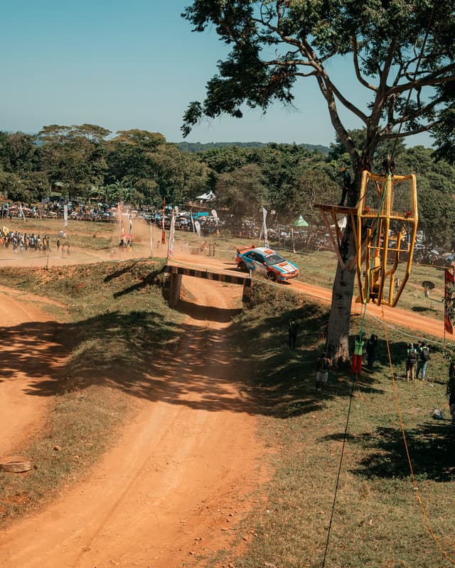 Rally car approaching a dusty jump