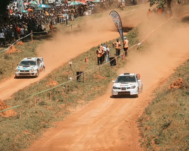 Two rally cars racing on the dirt track